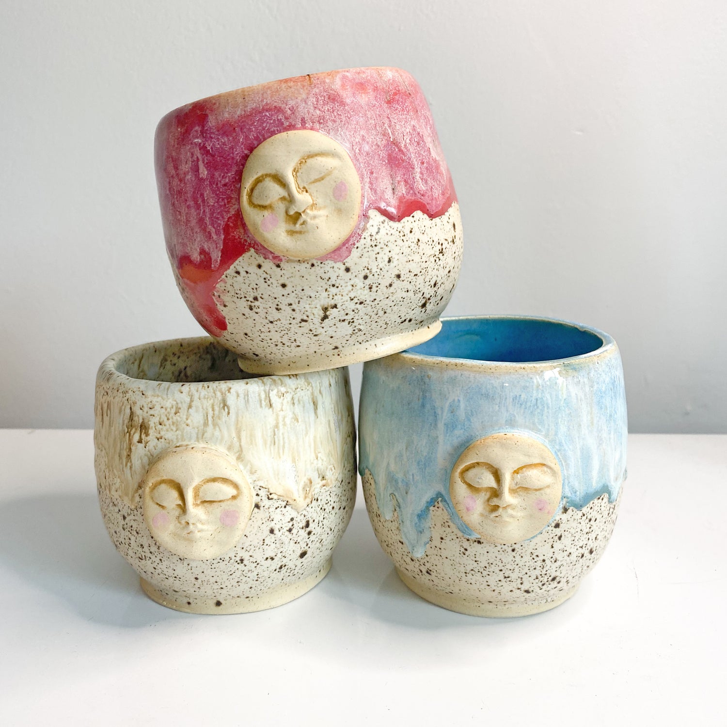 full moon cups made of stoneware clay. Three different variations raspberry, blue and sand. Handmade in South Florida by Island Girl Pottery